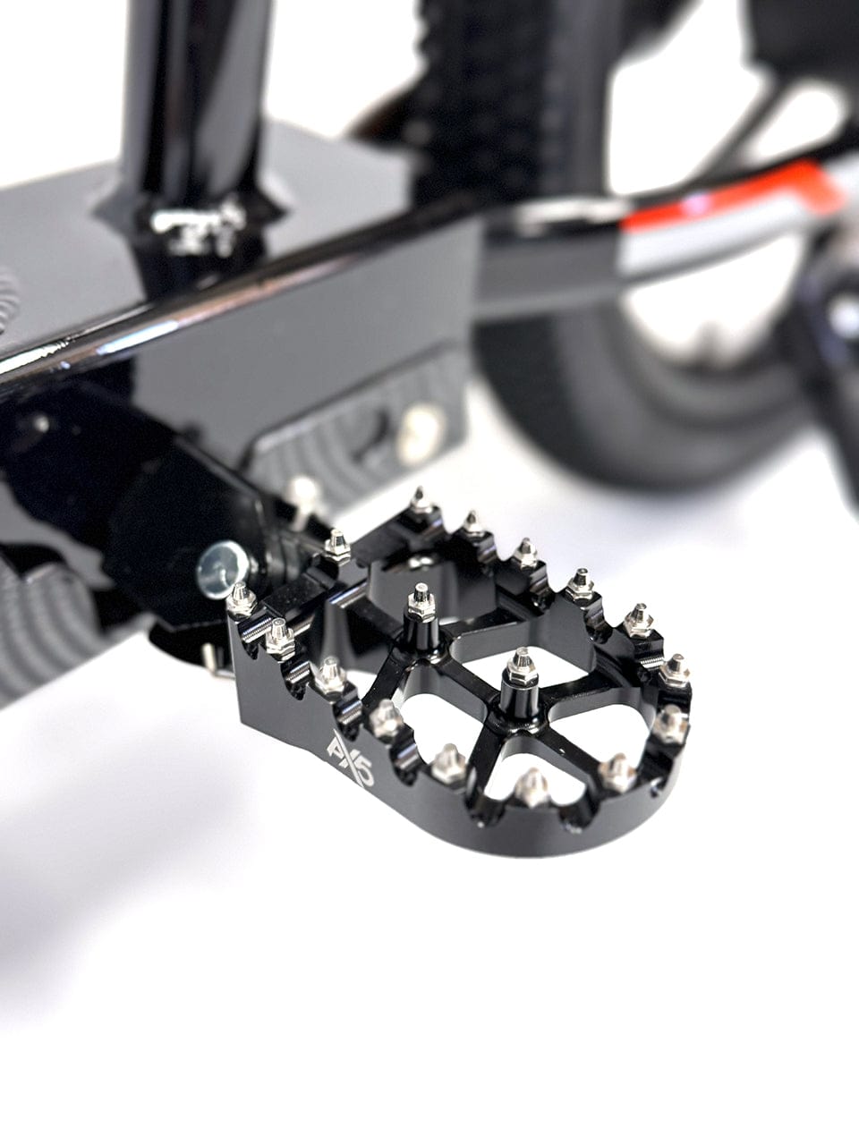 Close-up of metal foot peg with grip studs on electric balance bike