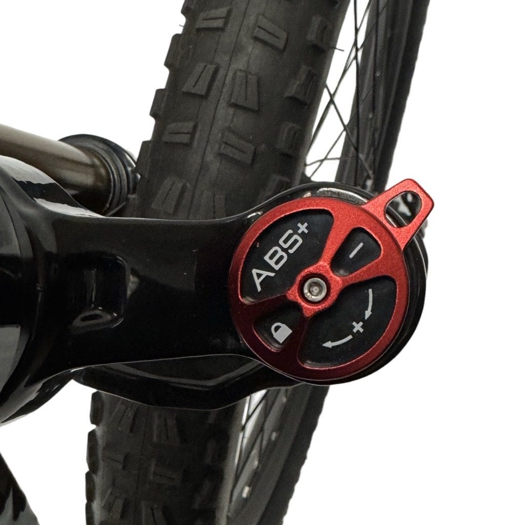 Close-up of bike suspension adjustment dial near front tire