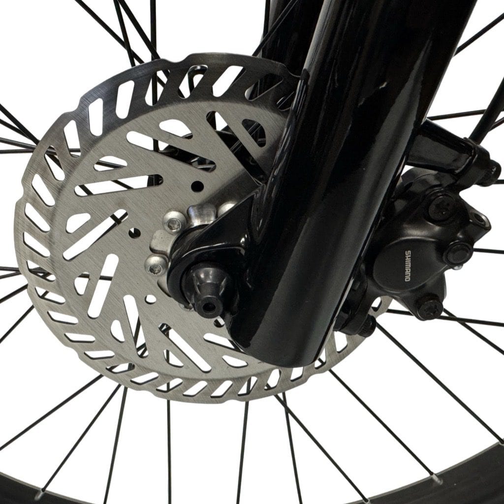 Close-up of front disc brake rotor and Shimano brake caliper on bike wheel