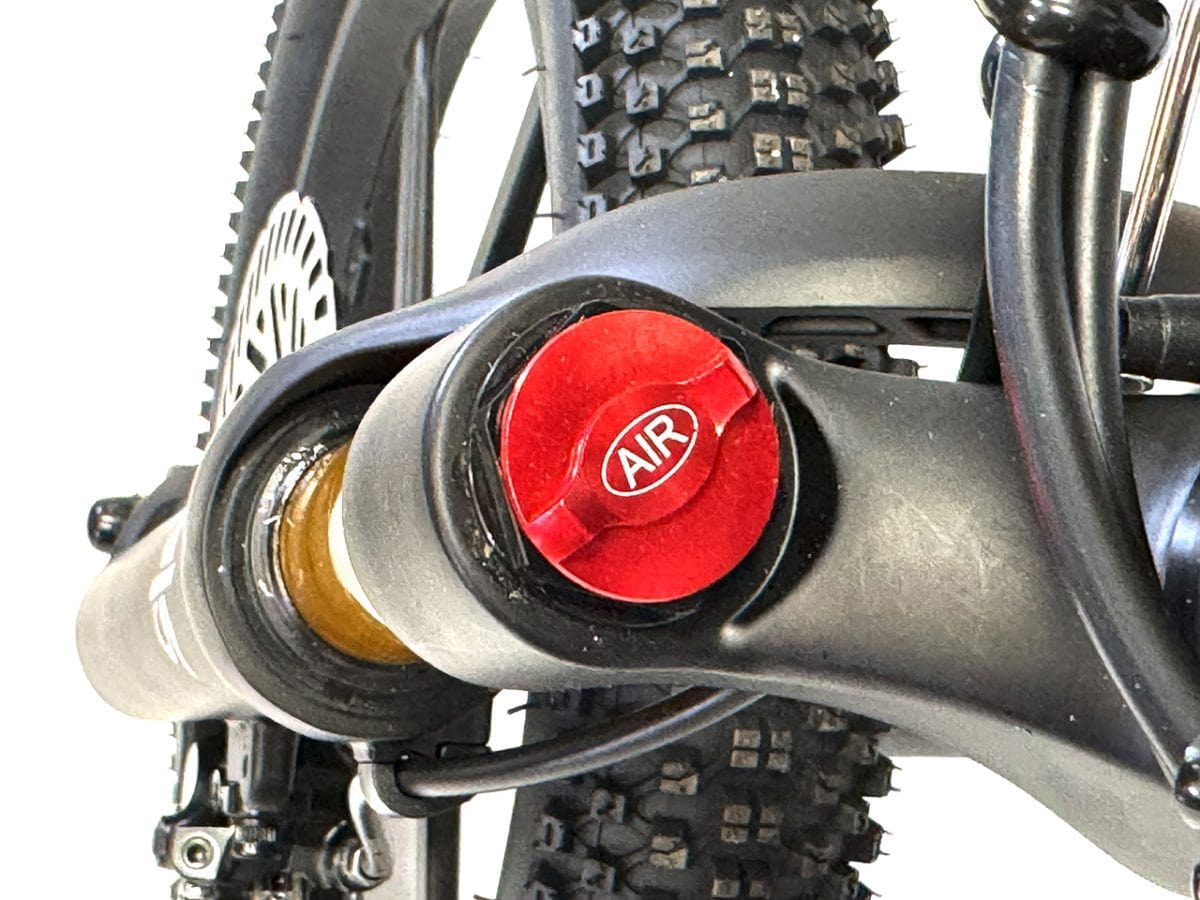 Close-up of front suspension adjustment cap on electric balance bike fork